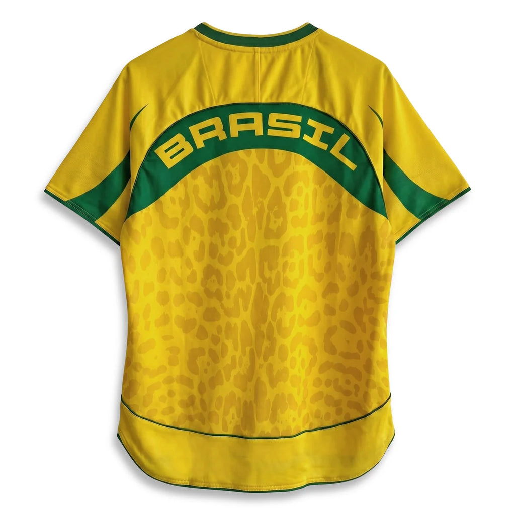 A Varldens yellow short-sleeve Brazil soccer jersey with a green and yellow leopard print pattern on the lower half, featuring a green arched collar band with 'BRASIL' printed in yellow across the shoulders.