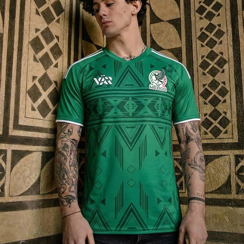 Front and back view of Mexico 2026 home jersey in green with Aztec geometric tribal patterns on display mannequin