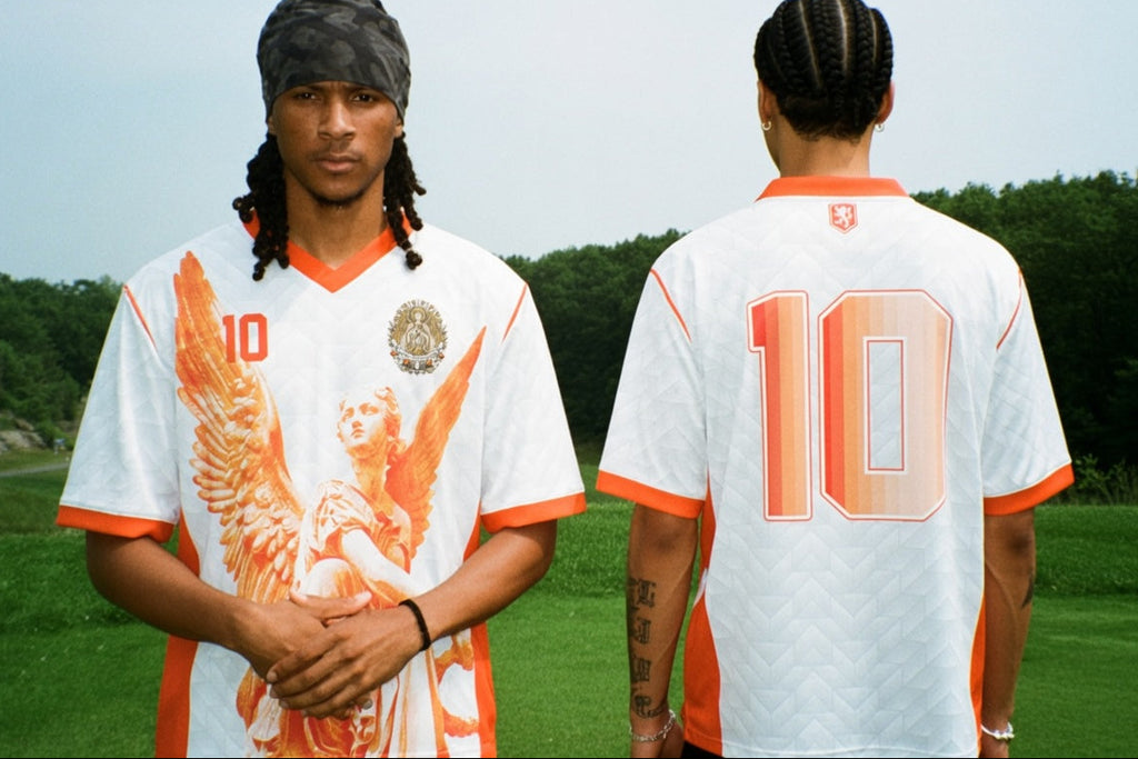 Front and back view of Netherlands 2026 away jersey in white with orange Guardian Angel graphics and retro chevron patterns