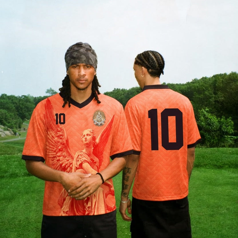 Front and back view of Netherlands 2026 home jersey in orange with Guardian Angel graphics and retro chevron patterns
