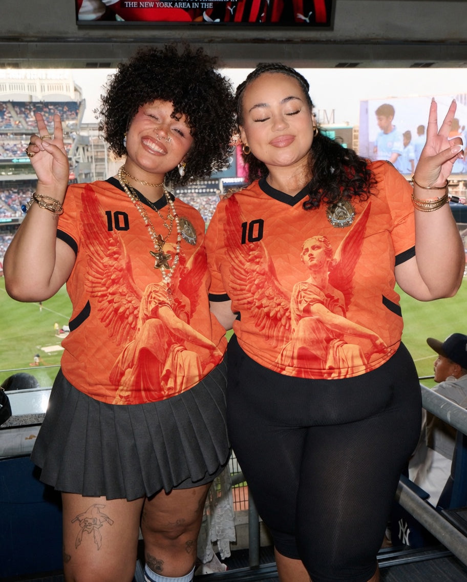 Front and back view of Netherlands 2026 home jersey in orange with Guardian Angel graphics and retro chevron patterns