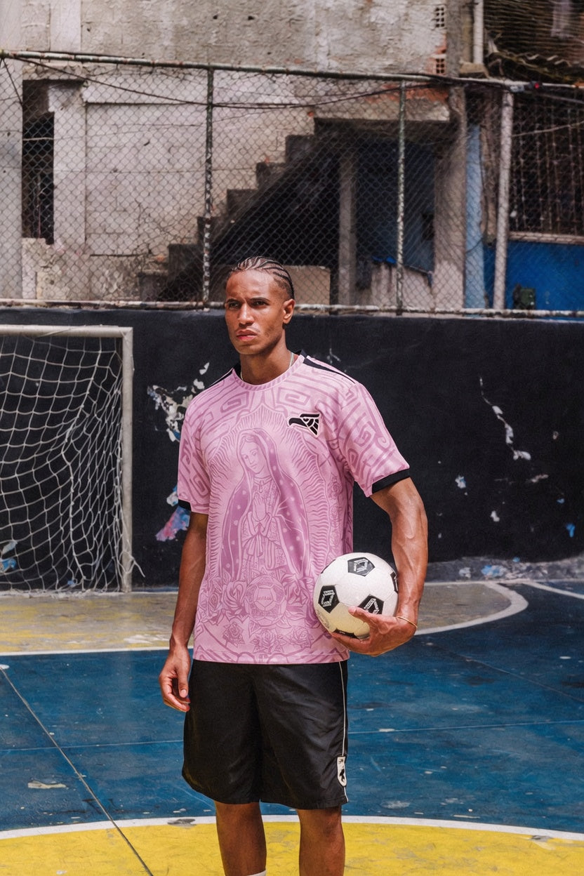 Man styling Varldens pink Mexico football shirt with Our Lady of Guadalupe art and azteca back print for a Blokecore streetwear look